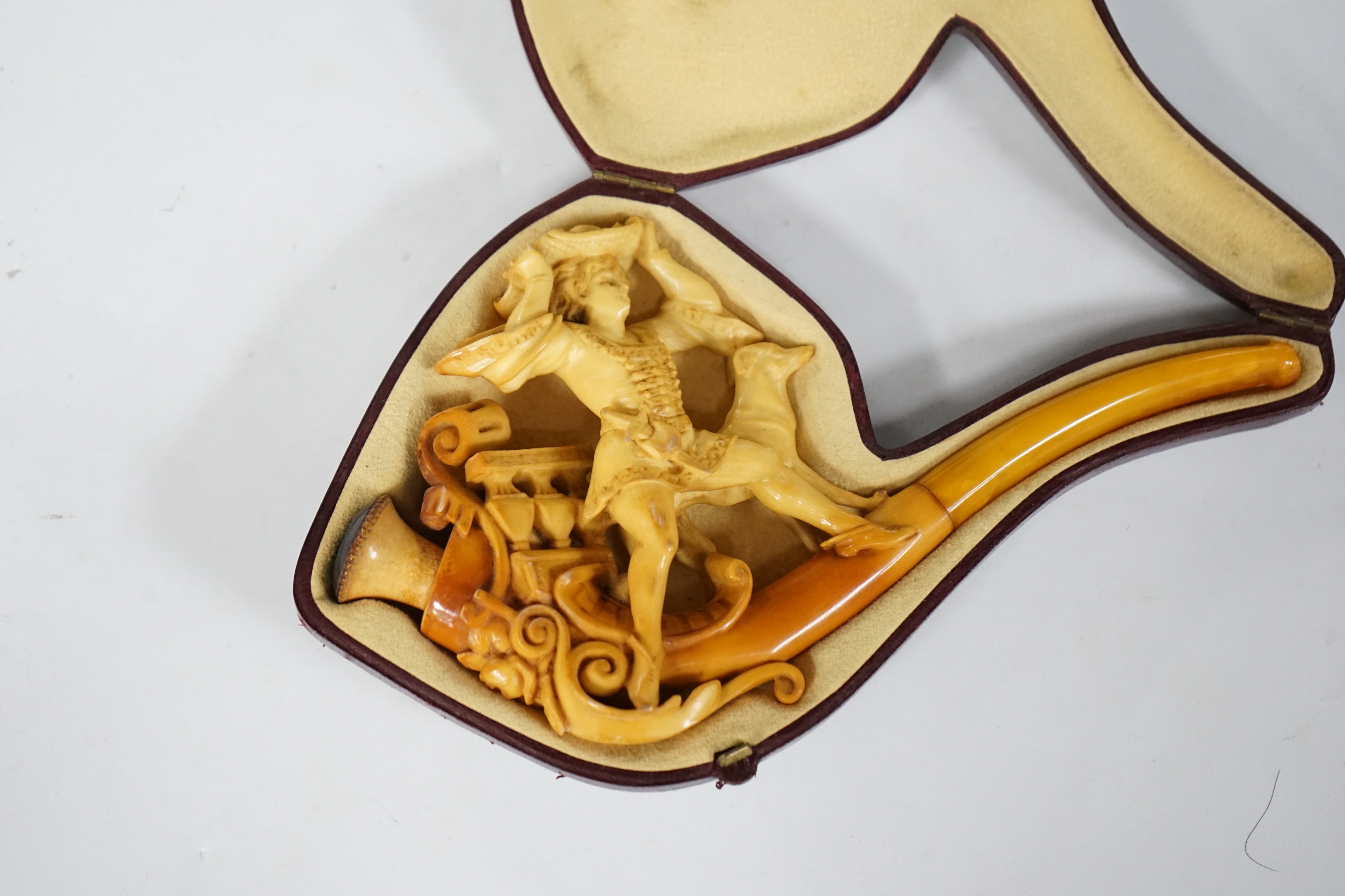 A cased Meerschaum pipe, the bowl in the form of a 17th century huntsman with his dog, 19cm long